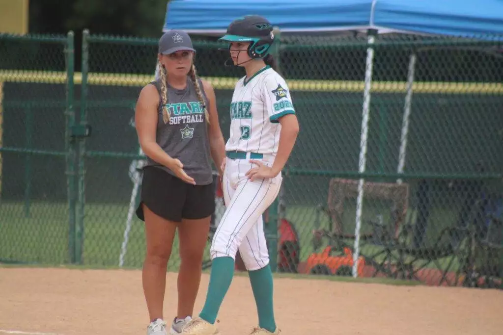 Coach Cara and #13 Kimberlin Barnes at first base in Apex, NC on July 19, 2025